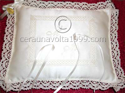 Cuscino portafedi in raso con iniziali ricamate.
Colore beige.
